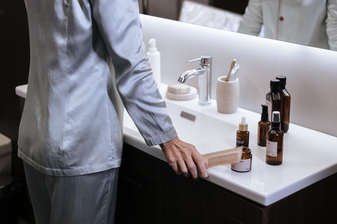 Older person at a bathroom sink. Illustrative stock photograph