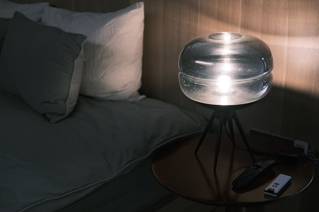 Illuminated bedside table at night. Illustrative stock photograph