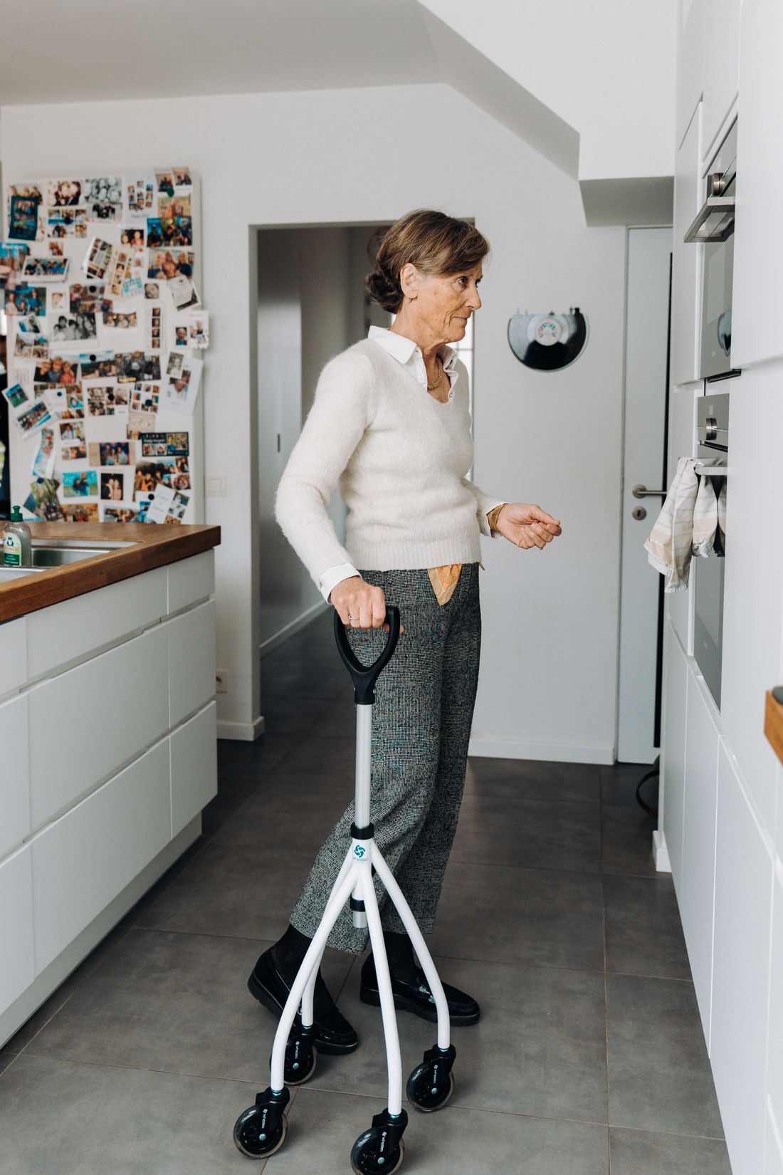Older woman with cane in a kitchen. Illustrative stock photograph